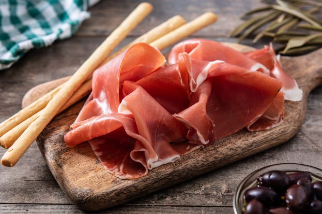Prosciutto di Parma with olives and breadstick. Image by chandlervid85 on freepik.com