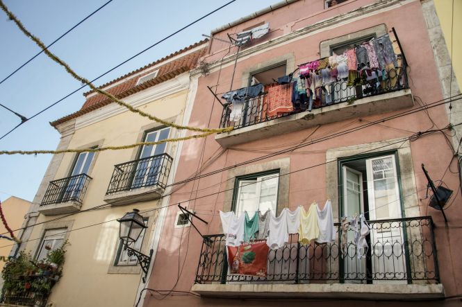 Clothes hanging from balconies in Lisbon Old Quarter. Photo by Ximena Nahmias on Unsplash