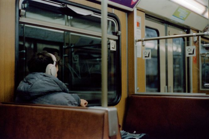 A person sitting on a train looking out the window. Photo by Ivan Mani on Unsplash 