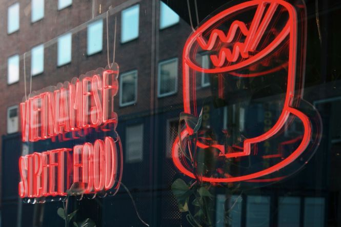 A red neon sign that is on the side of a building. Photo by Preslav Rachev on Unsplash