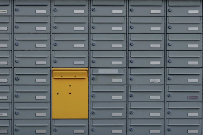A wall of gray mailboxes. Photo by Janis Ringli on Unsplash